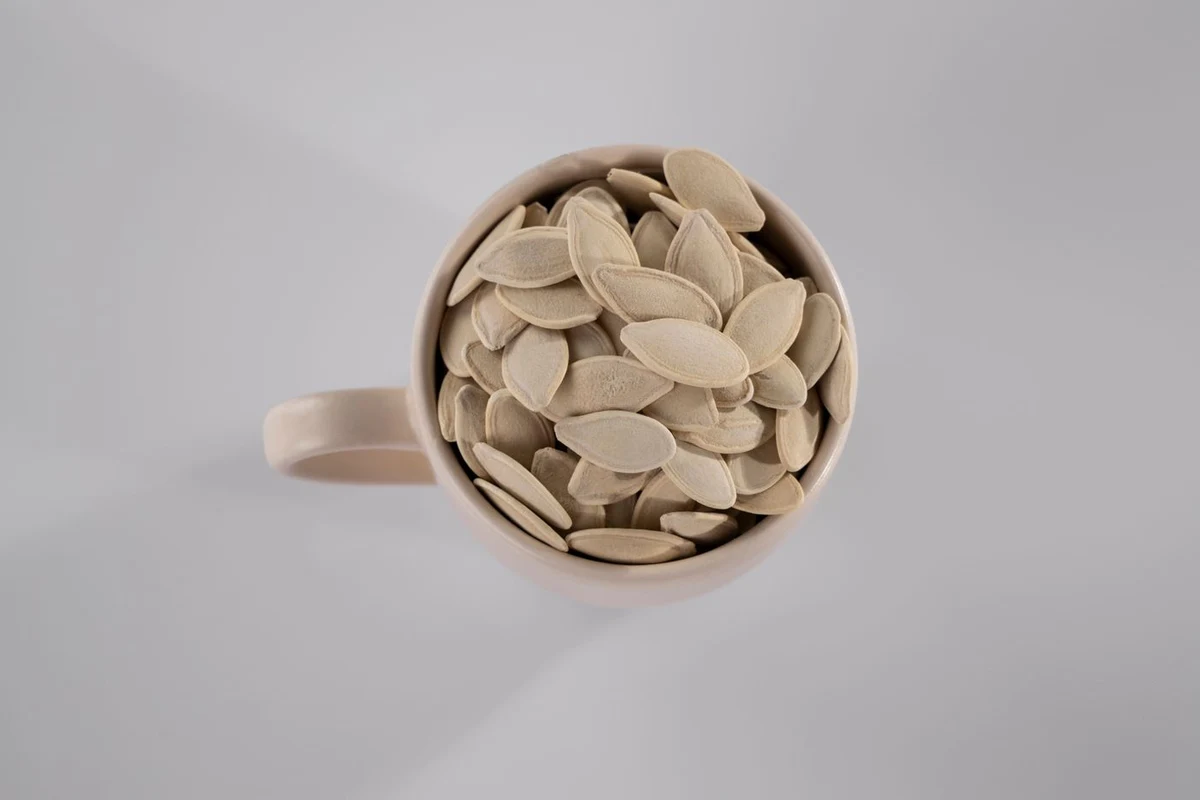 Fresh whole pumpkin seeds in a cup ready to serve to birds